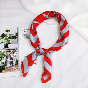 Detail of red and silver striped silk scarf styled in a ring knot on white fabric
