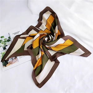 Detail of silk-like geometric scarf with mustard yellow and olive green block patterns