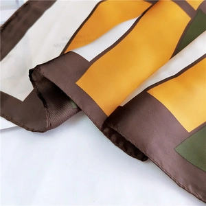 Silk-like square scarf featuring geometric color blocks in brown, orange, and green colors