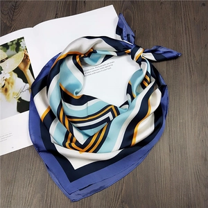 Detail of silk satin square scarf with colorful geometric stripes and contrast border