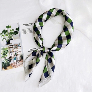 Elegant green and navy blue plaid silk scarf styled as a neckerchief on white fabric