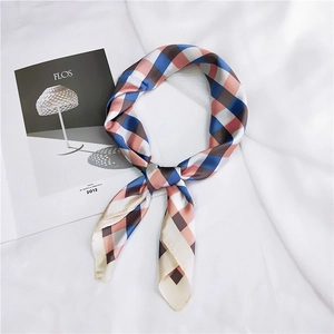 Close-up of knotted colorful checkered silk square scarf with premium smooth texture