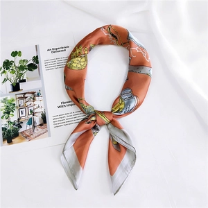 Détail du foulard vintage en soie avec motifs de calèches orange et finition satinée