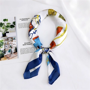 Détail d'un foulard en soie carré avec imprimé équestre, mors et motifs dorés