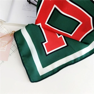 Macro detail of silk square scarf featuring letter P print and vintage varsity color block
