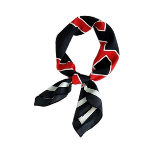 Elegant red black and white geometric silk scarf tied in a bow with smooth texture