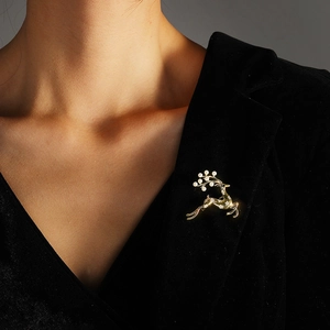 Elegante spilla a forma di cervo dorato con perle e cristalli su blazer di velluto