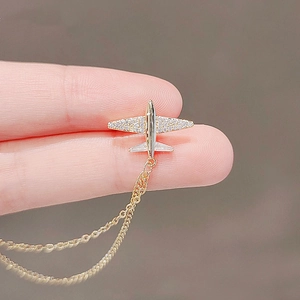 Golden airplane brooch with sparkling zircon wings and elegant hanging tassel chains