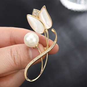 Eleganter goldener Tulpen-Brosche mit Perlen- und Muschelblättern in der Hand