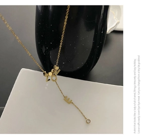 Detailed view of a gold Y-shaped necklace featuring LOVE letters and a zircon crystal