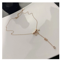 Detail view of rose gold LOVE necklace with long Y-chain and clear round zircon