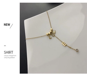 Detail of gold LOVE letter Y-shaped titanium steel necklace with a zircon drop accent