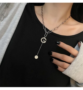 Detail of titanium steel G letter pendant necklace worn on neck with chunky chain