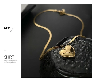 Detail of 18K gold heart pendant with 'Love You More' engraving on a snake chain