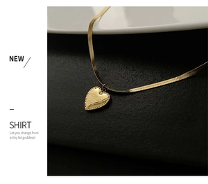 Close-up of gold heart pendant with Love You More engraving on sleek snake chain