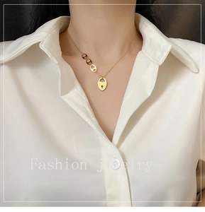 Vue détaillée du collier cadenas en acier titane doré style vintage sur col de chemise