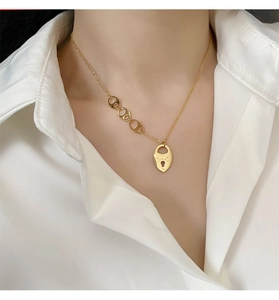 Gros plan d'un collier doré en titane avec maillons ovales et pendentif cadenas Lucky