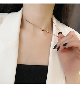 Detailed view of triple 18k rose gold butterfly pendants on a dainty collar necklace
