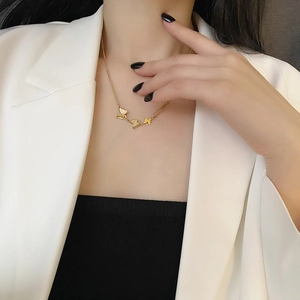 Elegant 18k gold butterfly necklace with mixed chain design on a stylish model