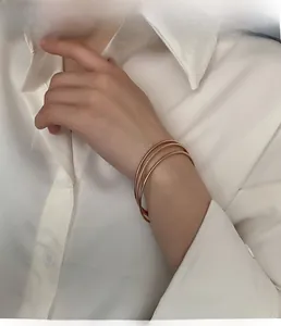 Detail view of a rose gold triple-layered interlocking bangle with glitter finish