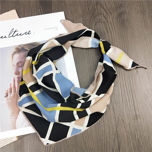 Eleganter Seidenschal mit geometrischem Druck und bunten Blöcken auf dunklem Holz