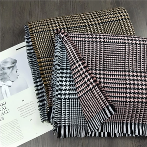 Thick houndstooth cashmere scarf set with tassels in yellow and pink on wooden background