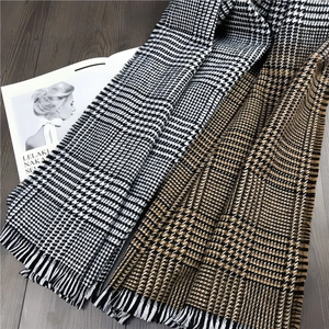 Detail of soft cashmere-like houndstooth scarf showing fine fringe edges and knit texture