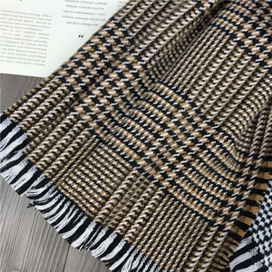 Detail of thick cashmere-like scarf showing classic houndstooth pattern and white tassels