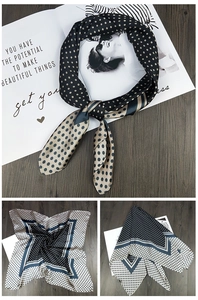 Detail of silk square scarf featuring polka dots and blue geometric stripes on wood