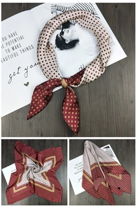 Detailed view of square silk scarf with classic polka dots and geometric borders