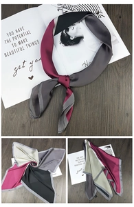 Detail showing geometric color-block silk scarf with matte satin finish and premium texture