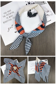 Detail of navy blue and orange geometric silk-like square scarf on wooden texture