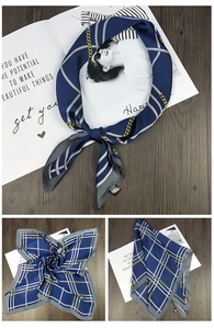 Detail of silk square scarf in navy blue with gold chain pattern and grey borders