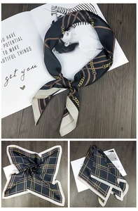 Detail of navy blue square silk scarf with vintage chain patterns and grid design