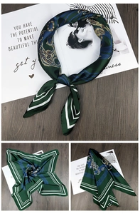 Detail of elegant dark green silk square scarf with vintage chain patterns and magazine decor