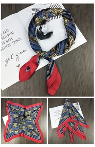 Detail view of square silk scarf featuring red borders and navy chain patterns