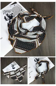 Détail d'un foulard en soie aux motifs géométriques noir, blanc et marron élégant