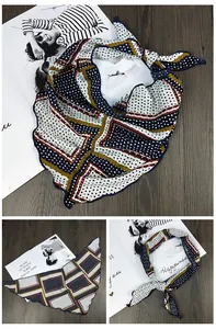 Détail du foulard en soie à pois marine et bordures géométriques jaunes sur bois