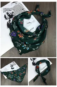 Détail d'un foulard en soie vert foncé avec tissage à chevrons et bords ondulés