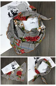 Détail d'un foulard triangulaire en soie avec motif pied-de-poule et imprimé roses