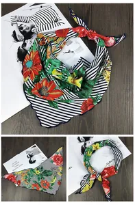 Détail d'un foulard triangle en soie avec rayures et bordure bleue ondulée