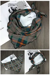 Détail du foulard triangle à carreaux montrant la maille verte et les bords festonnés