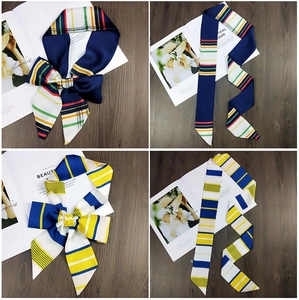 Detail of navy and yellow striped silk scarf showing bow knot and long flat layout
