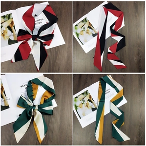 Detailed view of color-block striped twilly scarves in red, black and green silk texture