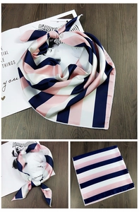 Detailansicht eines gestreiften Seidenschals in Marineblau und Rosa auf einem Magazin
