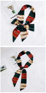 Macro detail of dark green and red striped satin twilly scarf tied in a chic bow
