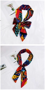 Detailed view of a long skinny silk scarf with vibrant abstract geometric patterns