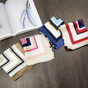 Silk square scarves set with V-shaped chevron pattern on dark wooden background