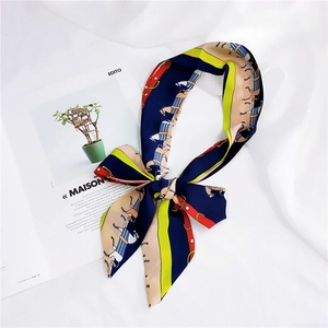 Close-up of a French style silk twilly scarf with horse patterns tied in a bow