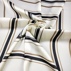 Detailed view of the silky fabric showing black and gold geometric stripes texture